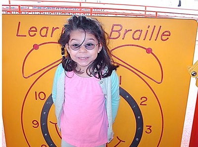 a child standing in front of the Braille Wall